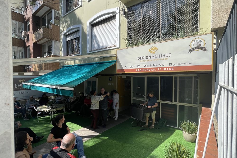 Fachada da Gerion Moinhos com toldo verde-água e jardim